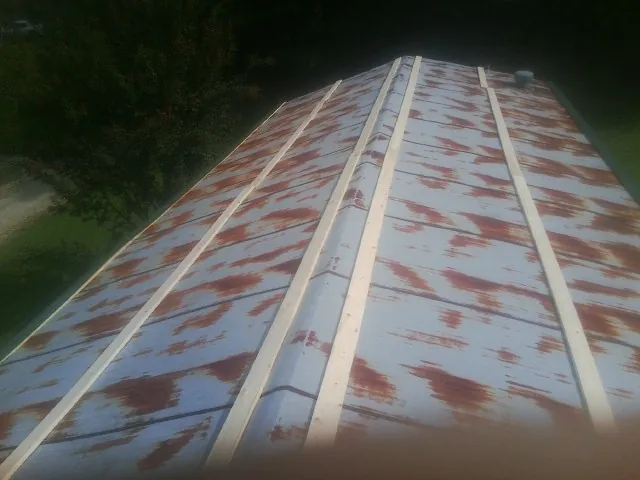 Rusted metal roof panels with new wood purlins before replacement — Storm Damage Roof Repair in Apison by Roofing Brothers