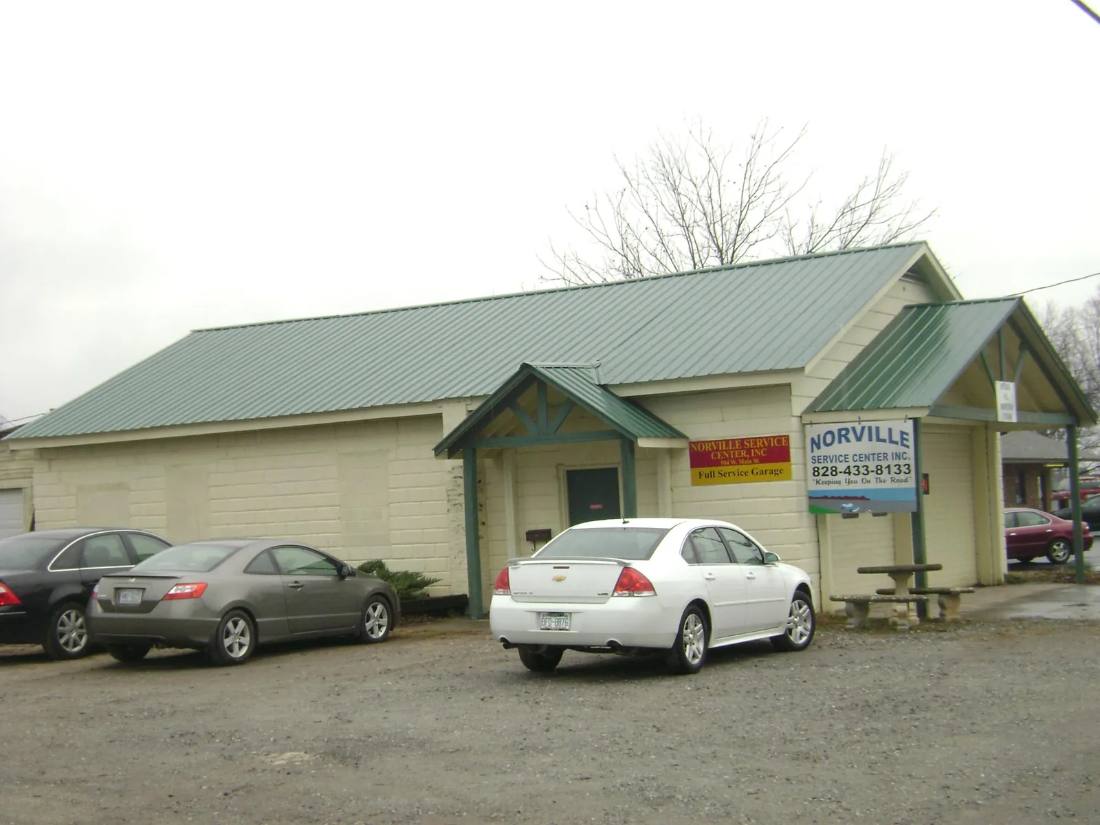Green metal roof on a service garage with a covered entry in Apison