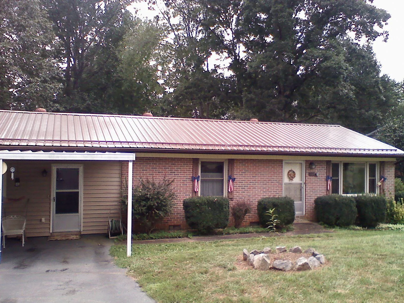 Bronze metal roof and carport on a brick ranch home — Roof Repair work by our crew in Apison